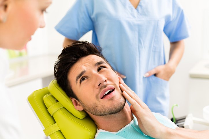Man with toothache in dentist’s chair